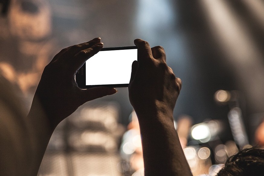 Des mains qui tiennent un smartphone et filment une scènehone halten und eine Bühne filmen