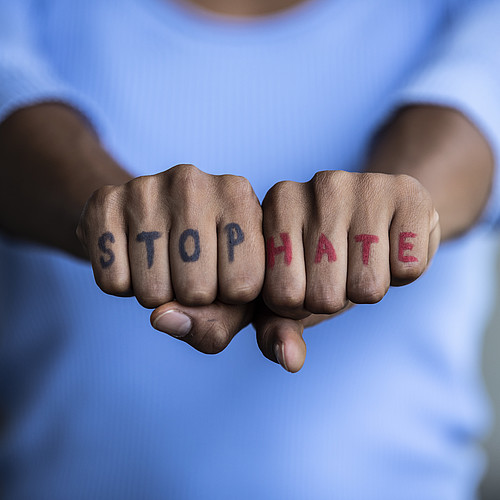 Deux poings avec "Stop Hate" écrit dessus.