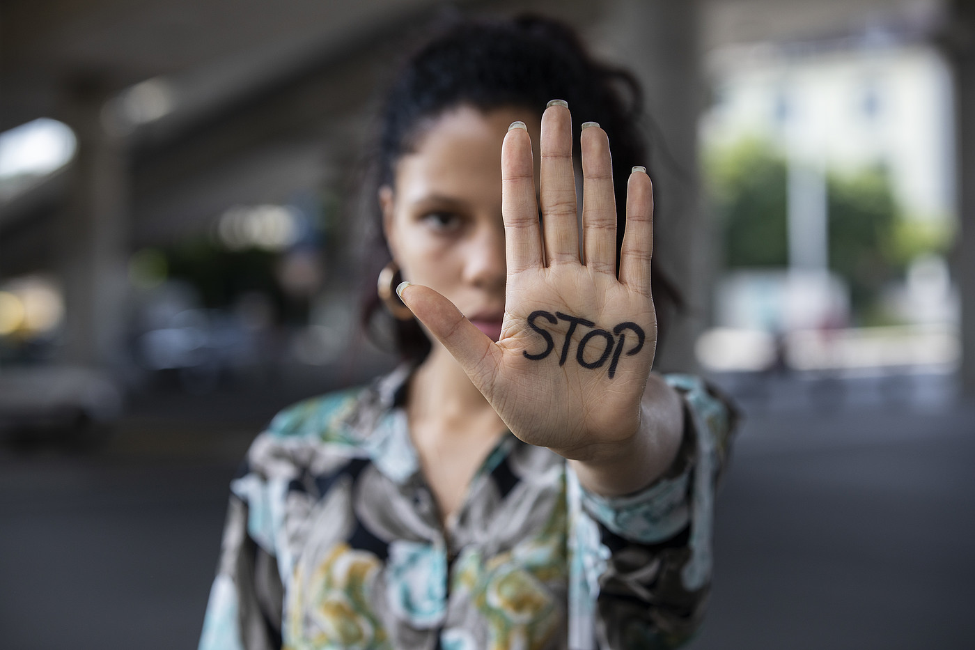 Une jeune femme lui tend la main avec le mot STOP écrit dessus.