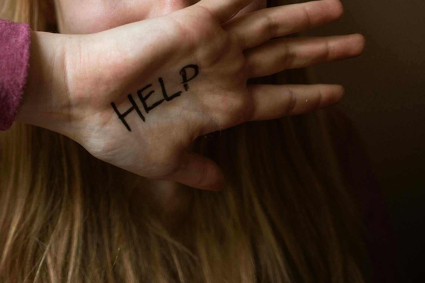 La main d'une femme avec "Help" écrit dessus